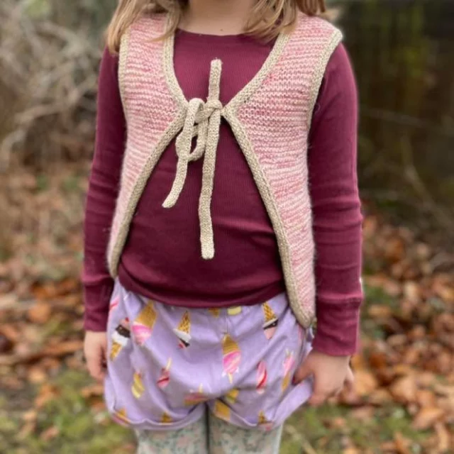 🌸 LONELY LEFTOVERS MINI 🌸  Åh, den här fina lilla västen, vilket guld den blev! 😍 Bokstavligt talat, hahaha. Jag har varit sugen på att sticka den här västen av @woolandbeyond sedan den släpptes men behövde marinera mina idéer ett litet tag innan jag kom till skott.  Tillslut föll mitt garnval på ett sockgarn från Myrans maskor som jag redan hade i gömmorna (ingen aning om vilken färg det är men tror tyvärr inte det är en färg som finns kvar) tillsammans med en tråd Alpakka Følgetråd i färg 3509 Ballet Tutu. Guldkanterna är en rest jag sparat sen jag gifte mig (2016!) och stickade en ganska illa sittande kofta till mig själv, hahaha. Koftan vet jag inte var den är men garnet fanns kvar och passade ju toppen till en väst till min femåring! 🤩  Västen är rolig att sticka och går väldigt fort och jag kan verkligen rekommendera att göra som jag gjorde - ta något garn ni har hemma, använd något annat till oket om ni inte har tillräckligt mycket, komplettera eventuellt med någon snygg följetråd och ba kör! 🥰  (Swipea för bonusbild på mig när jag bär guldkoftan och min man skriver på giftaspapprena på min rygg 😂)  #knutengarn #knutenjkpg #lysjkpg #jkpgsöder #jönköpingsöder #garnaffärijönköping #stickgäris #diy #slowfashion #yarninspo #knitting #sticka #knittersofinstagram #elinberlin #woolandbeyond #schachenmayrmiracle #myransmaskor #myransmerinosock #sandnesalpakkafølgetråd